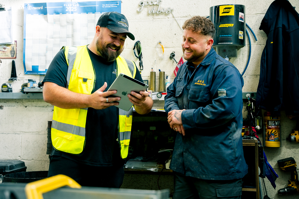 Shropshire Welding Solutions technicians reviewing a tablet in the workshop.
