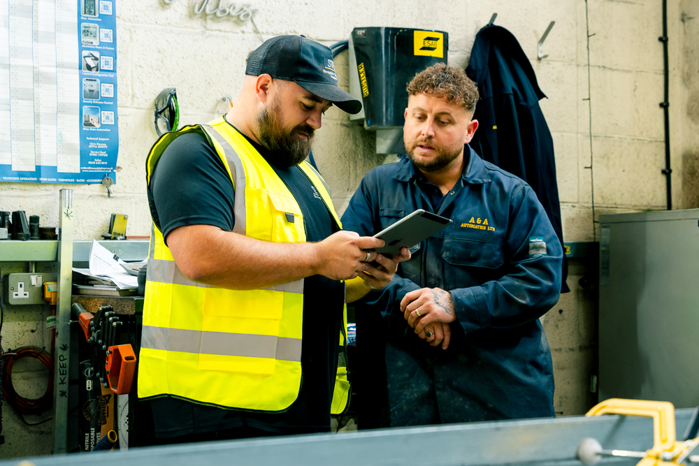 Technician wiring and testing electrical equipment in a workshop.