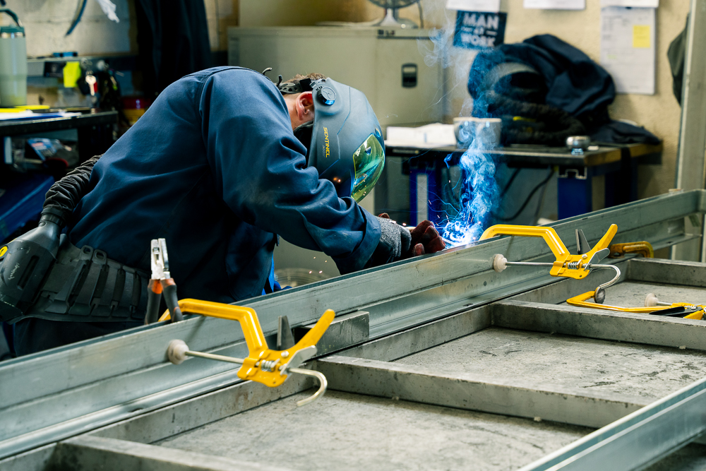 Welding clamps securing metal frame during fabrication.