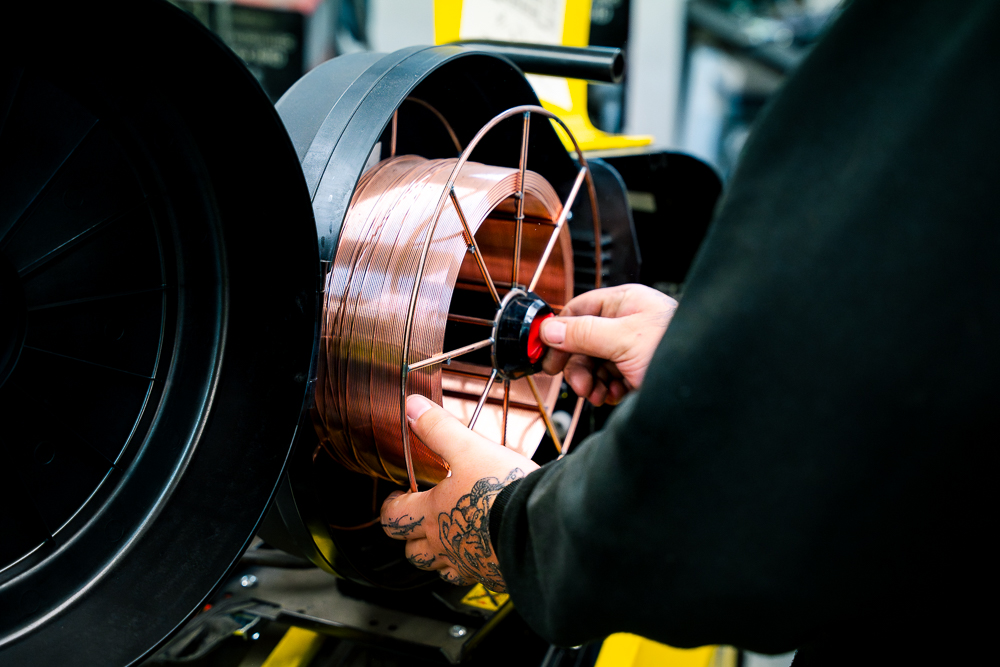 Close-up of a welder working on metal fabrication in a workshop.