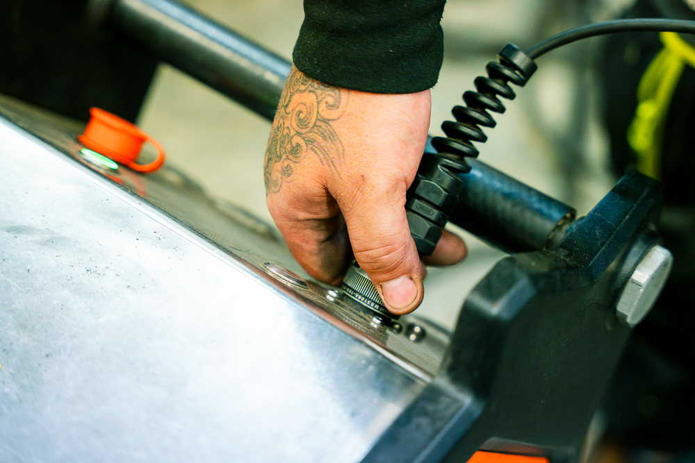 Close-up of a hand adjusting machinery in a workshop.